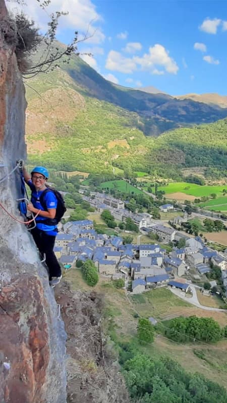 Persona escalando la Vía Ferrata Roca Carrera con vistas panorámicas al Vall de Boí.