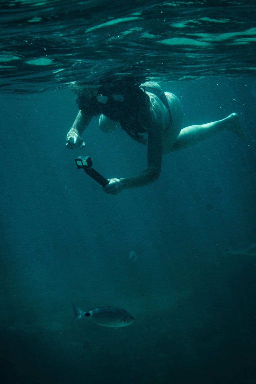 Pareja disfrutando de una ruta en moto de agua cerca de una lancha motora en las calas de Menorca.