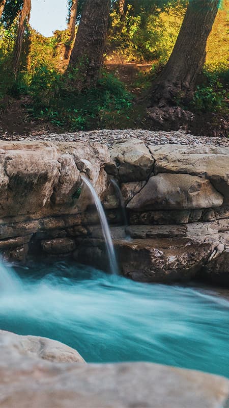 Pareja remando coordinada en un canoaraft neumático superando un rápido en el río Cabriel.