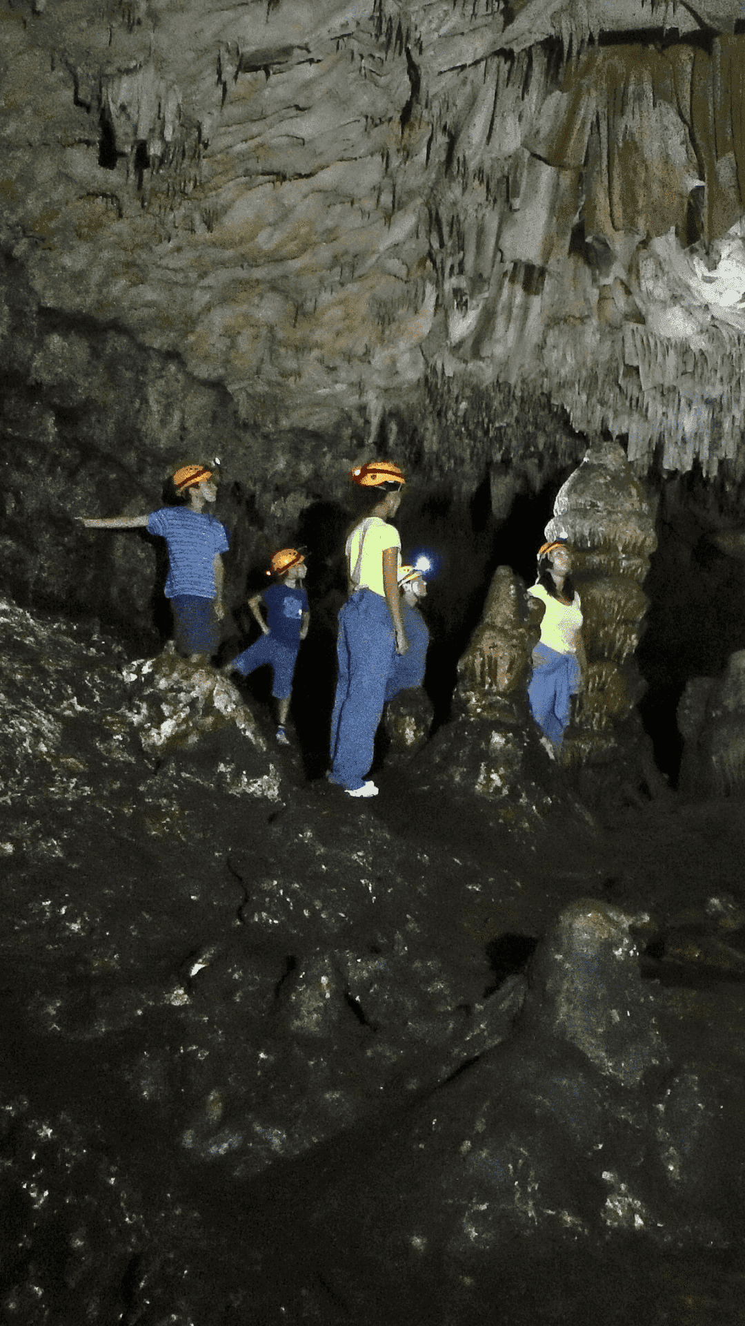 Grupo de personas con cascos y frontales explorando una cueva natural en Venta del Moro.