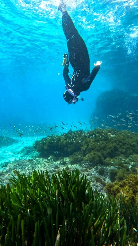 Explorador utilizando un scooter subacuático para hacer snorkel en las aguas cristalinas de Maro, Nerja.