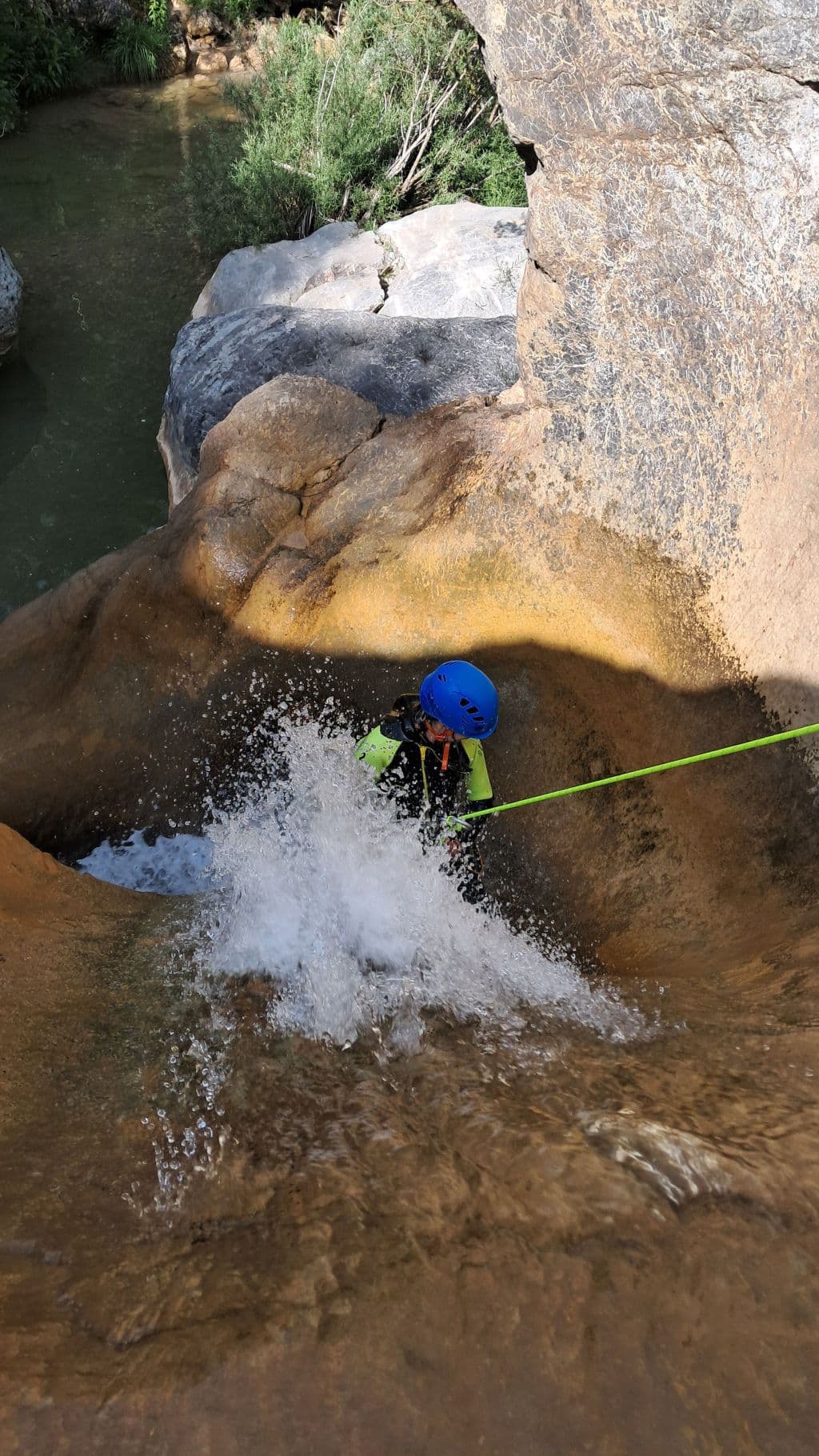 Deportista realizando un rápel en una cascada del barranco de Viu de Llevata, Pirineos.