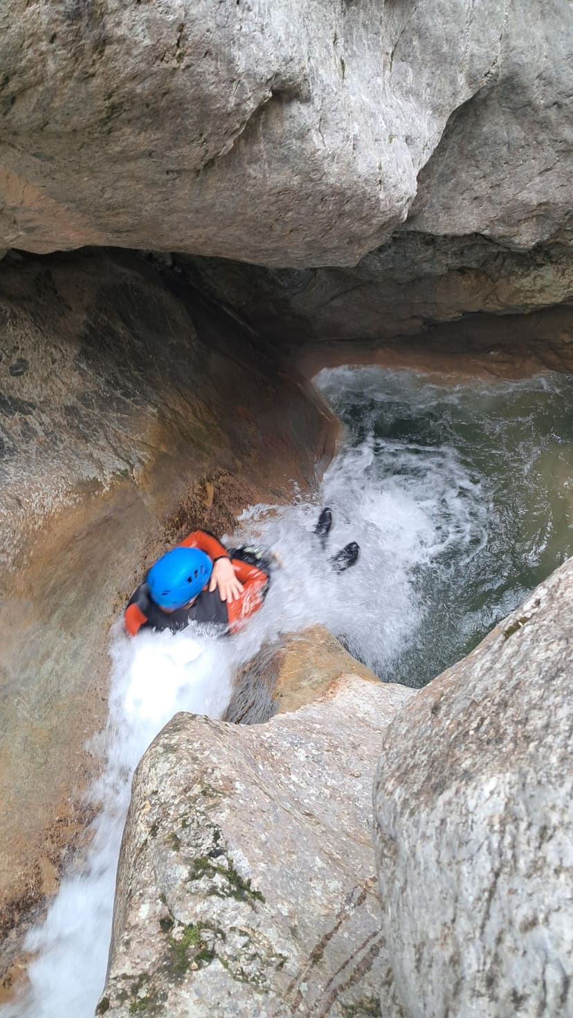 Deportista realizando un rápel en una cascada del barranco de Viu de Llevata, Pirineos.