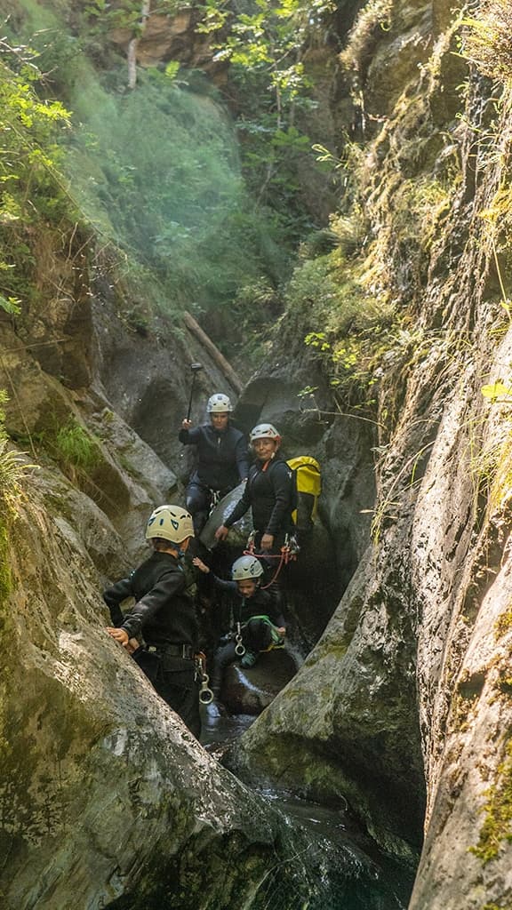 Persona descendiendo por un tobogán natural de agua en el Barranco de Berrós, Pirineos.