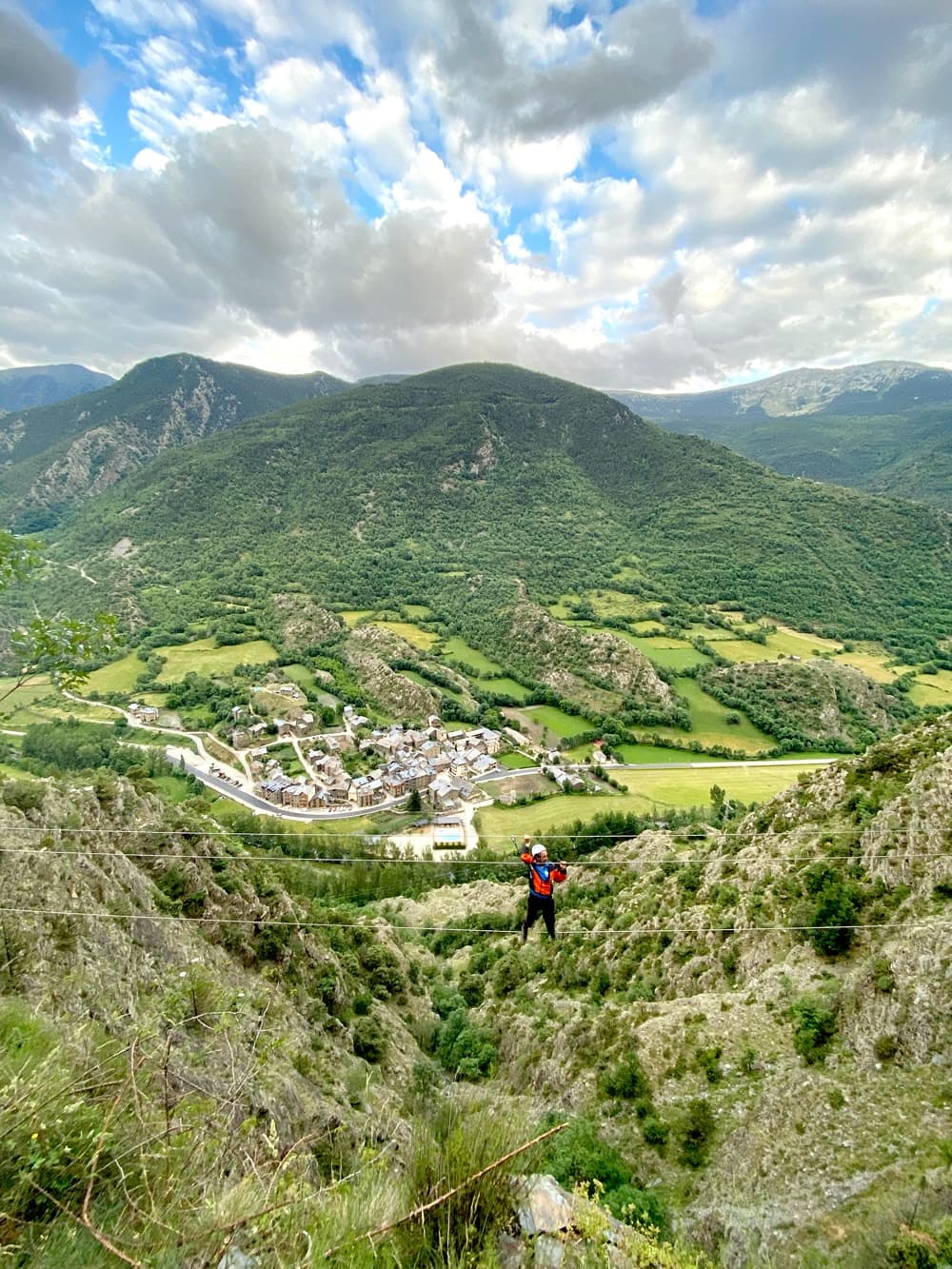 Persona equipada con arnés y casco progresando por los peldaños metálicos de la Vía Ferrata Salt del Botanal en Alins.