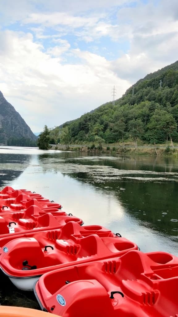 Grupo de niños lanzándose por el tobogán de un patín acuático de pedales en las aguas tranquilas del lago de La Torrassa.